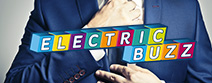 Electric Buzz spelt in blocks with man fixing tie as background