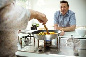 Man looking at food being cooked in a pan