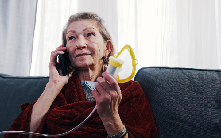 An elderly woman talking over a phone.
