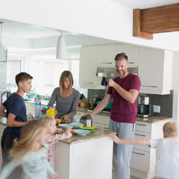 A morning kitchen scene with playful children and a man enjoying a coffee, capturing the warmth of a family breakfast setting.